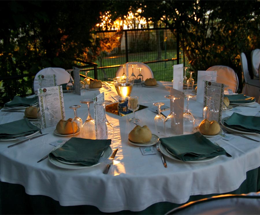 Mesa de boda montada en un jardín al atardecer.