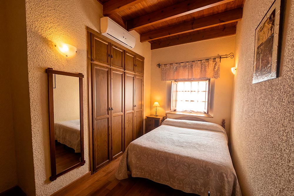 Habitación 103 Hotel Rural La Fábrica Fuente de Cantos Dormitorio con suelo y techo de madera, con un estilo rústico.