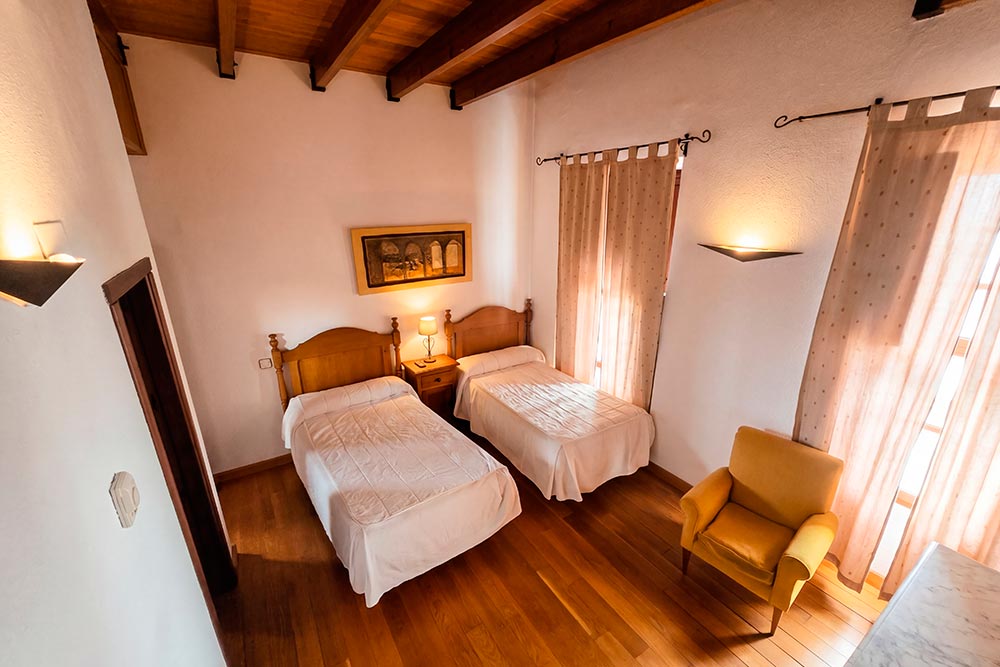 Pasillo Hotel Rural La Fábrica Fuente de Cantos Un pasillo estrecho con una alfombra en el suelo.